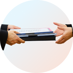 Zwei Personen übergeben sich eine Mappe mit Unterlagen – Symbol für das kostenlose Vermarktungskonzept von Firstplace Immobilien zur optimalen Verkaufsstrategie.